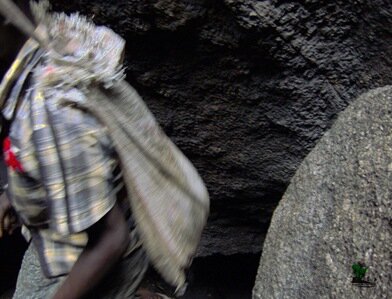 A hunter hurries along with a jute bag full of dead bats